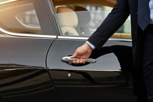 G4 Cars driver opening the door of a black executive vehicle